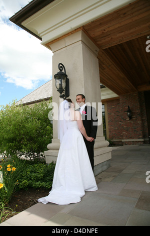Bride and Groom holding hands looking at each other Stock Photo