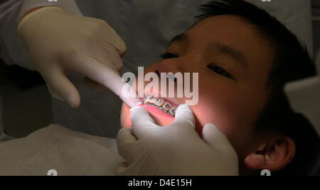 Dentists and dentistry students examine a patient at the dental and oral health clinic (Klinik für Zahn-Mund-Kieferkrankheiten) in Munich, Germany, 29 April 2008. After the total makeover of the Munich University's dental and oral health clinic, some 700 dentistry students are provided with the world's state-of-the-art education. Photo: Frank Leonhardt Stock Photo