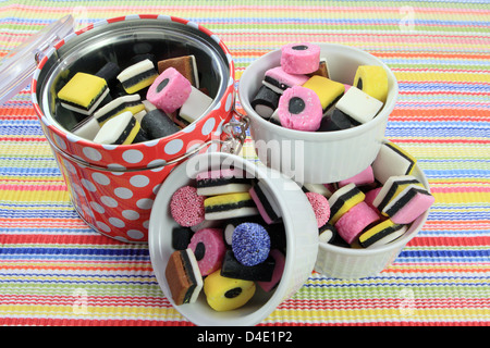 A container and three bowls full of liquorice sweets Stock Photo