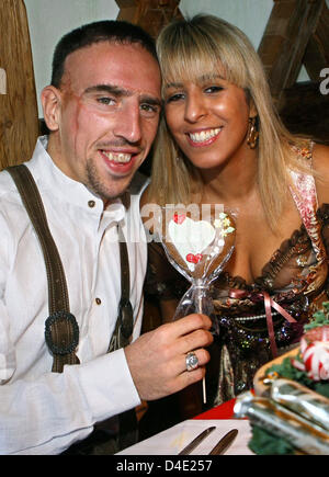 Franck Ribery and his wife Wahiba Ribery pose with the DFB-Trophy
