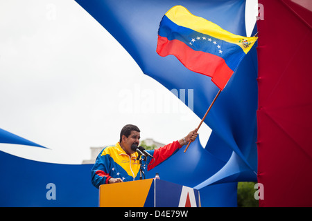 Venezuelan President in Charge Nicolas Maduro waves a national flag during the official registration of his candidacy