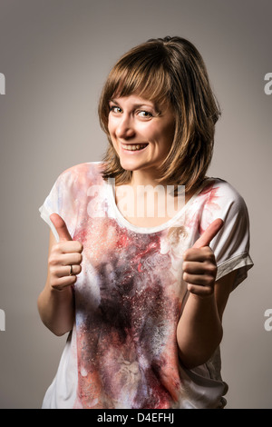 Laughing girl holds up hands with thumbs Stock Photo