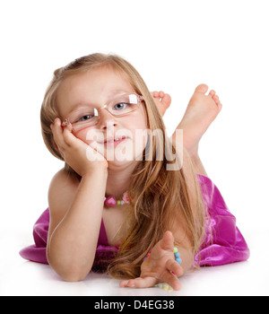 Portrait of a cute happy little girl in glasses laying on floor, isolated over white Stock Photo