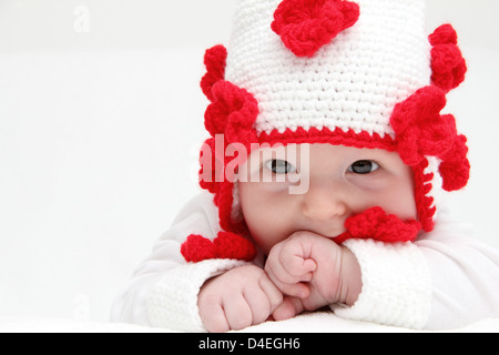 Little baby with knitted white hat baby on stomach Stock Photo