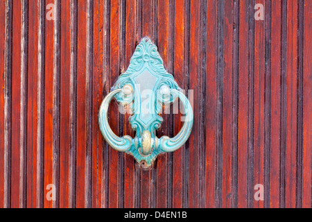 Ornate blue door knocker on old red door in Mykonos town, Greece, Mediterranean Europe Stock Photo