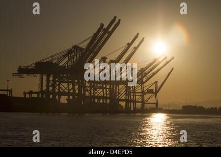 Long Beach, California, USA. 12th March 2013. The dark silhouette of the machinery and cranes of the container terminal stand against the backdrop of a sunset evening sky at the Long Beach Port , California on March 12, 2013. (Credit Image: Credit:  Ringo Chiu/ZUMAPRESS.com/Alamy Live News) Stock Photo