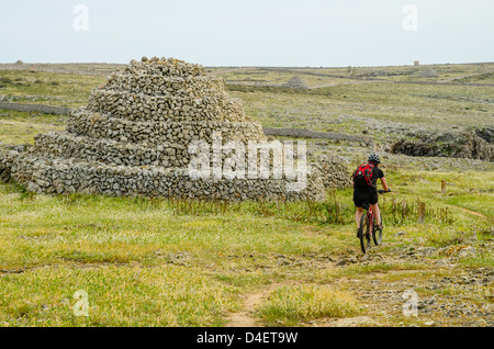 Mountain biker passing ancient stoneworks on the Cami de Cavalls coastal path on Menorca in the Balearic islands, Spain Stock Photo
