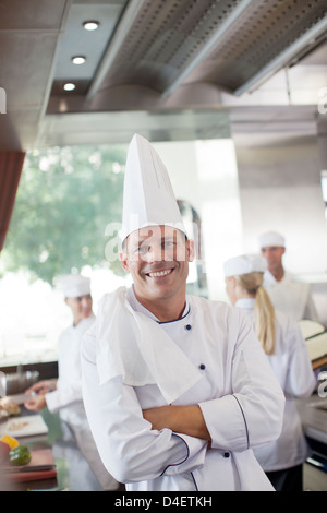 Chef smiling in restaurant kitchen Stock Photo