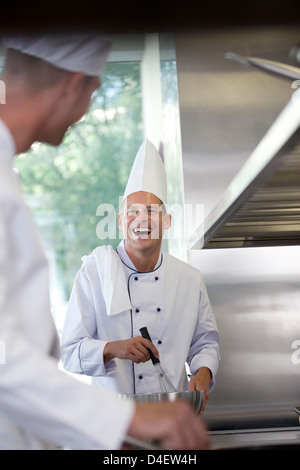 Chefs talking in restaurant kitchen Stock Photo