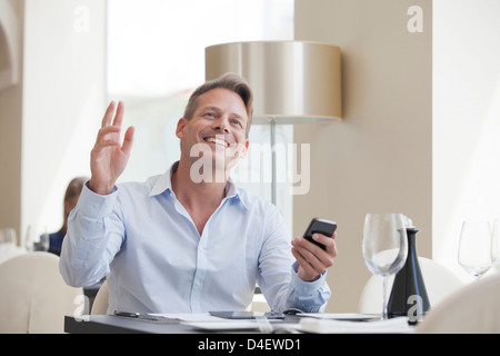 Businessman using cell phone in restaurant Stock Photo
