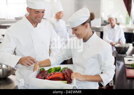 Chefs examining vegetables in restaurant kitchen Stock Photo