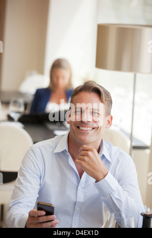 Businessman using cell phone in restaurant Stock Photo