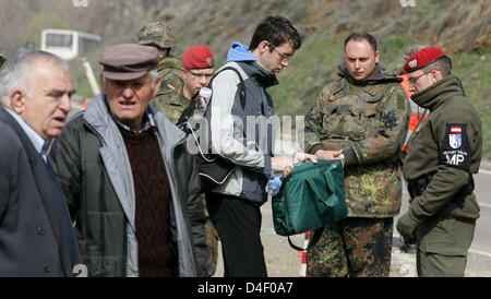 Soldiers of German Bundeswehr and Austrian Military Police inspect a driver during a street checkup north of Mitrovica, Kosovo, 04 April 2008. Photo: Matthias Schrader Stock Photo