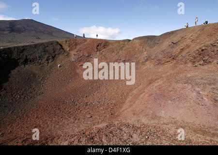 Tourists stand around rib of crater Formica Leo on Indian Ocean island ...