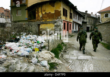 Two soldiers of German Bundeswehr patrol the destroyed and still closed ...
