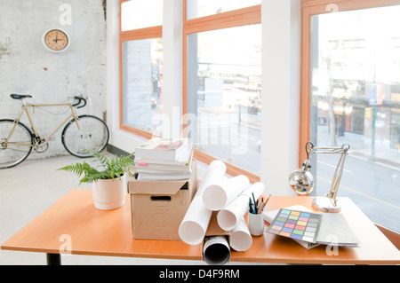 Blueprints and papers on desk in office Stock Photo