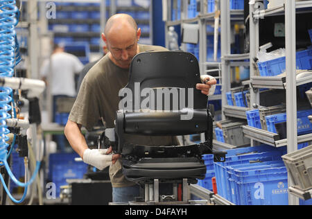 An employee of car supplier Grammer assembles a vehicle seat at the company's production plant in Amberg, Germany, 10 June 2008. Grammer, present in 17 countries with more than 9,000 employees, produces driver and passenger seats for vehicles, construction and farming machinery as well as components for car interiors. Photo: Armin Weigel Stock Photo