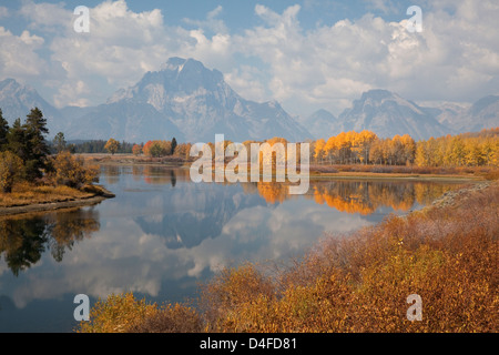 Mountains and sky reflected in still river Stock Photo