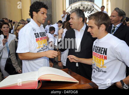 Michael Ballack (L) and Philipp Lahm (R) of Germany's national soccer team sign Berlin's 'golden book' next to Berlin's Lord Mayor Klaus Wowereit (C) in Berlin, Germany, 30 June 2008. Germany's national soccer team was received by hundreds of thousands of fans at Brandenburg Gate. The day before the team had lost the Euro2008 final against Spain 0-1. Photo: GERO BRELOER Stock Photo