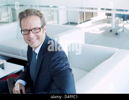 Businessman smiling in office lobby Stock Photo
