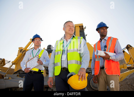 Businessmen in hard hats standing on site Stock Photo