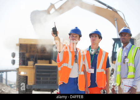 Workers and businessman standing in quarry Stock Photo