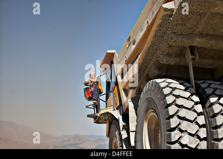 Worker standing on machinery Stock Photo