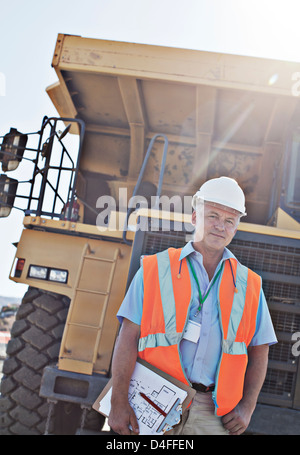 Worker holding clipboard on site Stock Photo