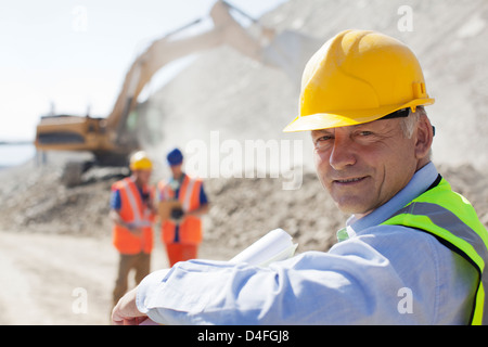 Businessman wearing hard hat in quarry Stock Photo