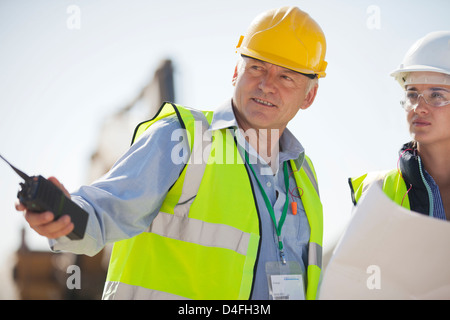 Business people in hard hats talking on site Stock Photo