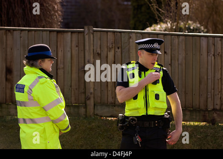 Police officer on phone with PCSO near scene of suspect arrested for threats to kill, Selborne, Hampshire, UK. Stock Photo