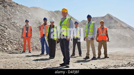 Business people and workers standing in quarry Stock Photo