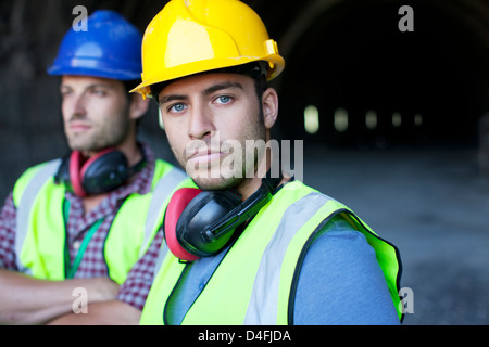 Workers looking out from tunnel Stock Photo