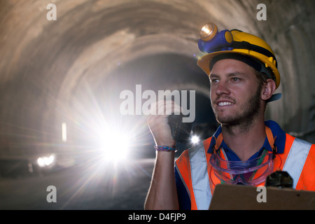 Worker using walkie-talkie in tunnel Stock Photo