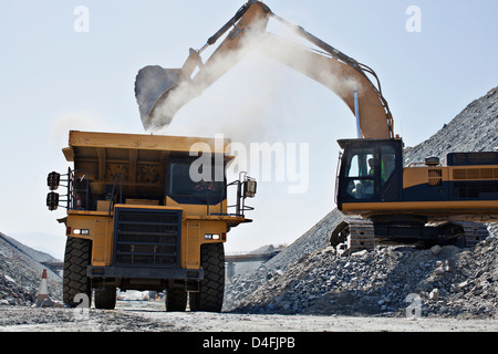 Digger and truck working in quarry Stock Photo