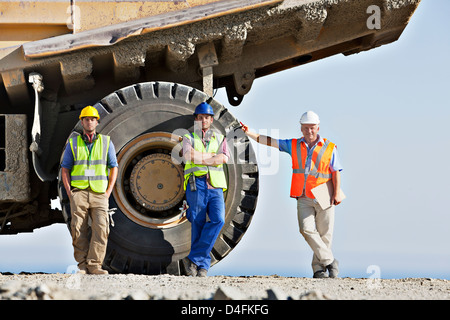 Workers standing by machinery on site Stock Photo