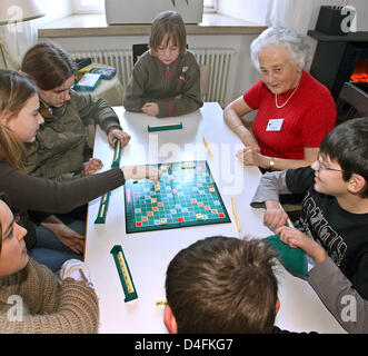 A senior citizen plays a board game with children in a so-called 'Mehrgenerationenhaus', a house uniting different generations under one roof, in Bad Woerishofen, Germany, 11 February 2008. Photo: Karl-Josef Hildenbrand Stock Photo