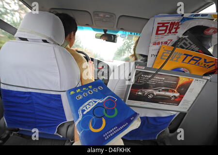 Taxi driver Gao Zhen poses with a Chinese-English dictionary for taxi drivers in Beijing, China, 10 August 2008. Photo: Karl-Josef Hildenbrand Stock Photo