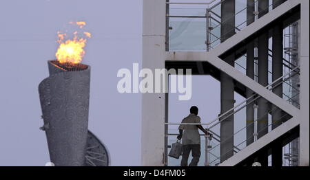 The olympic flame seen behind a staircase of the Ling Long Broadcasting Tower near the National Stadium in Beijing, China, 12 August 2008. Photo: Karl-Josef Hidenbrand dpa ###dpa### Stock Photo