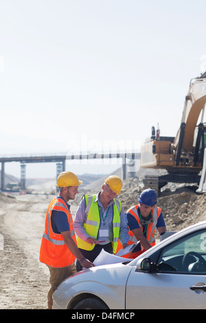 Businessman and workers talking in quarry Stock Photo