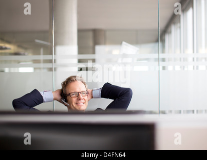 Businessman talking on headset in office Stock Photo