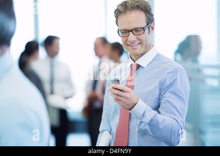 Businessman using cell phone in office Stock Photo