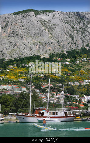 The photo shows the Croatian seaport Omis, situated 30 kilometres to the south of Split, which is one of the most charming towns of the Adriatic Sea in Dalmatia, Croatia, 08 June 2008. The city with its historic Old Town and fortress lies at the end of the canyon of Cetina and the river of the same name and in front of the steep chalk cliffs of the Omisko mountains. The varied land Stock Photo