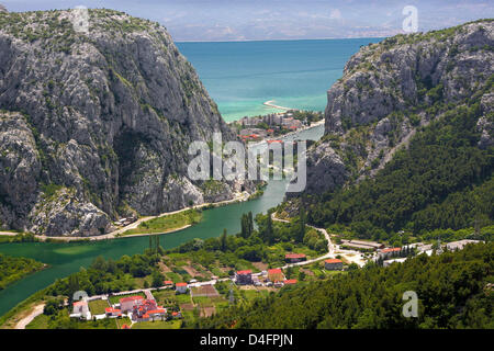 The photo shows the Croatian seaport Omis, situated 30 kilometres to the south of Split, which is one of the most charming towns of the Adriatic Sea in Dalmatia, Croatia, 08 June 2008. The city with its historic Old Town and fortress lies at the end of the canyon of Cetina and the river of the same name and in front of the steep chalk cliffs of the Omisko mountains. The varied land Stock Photo