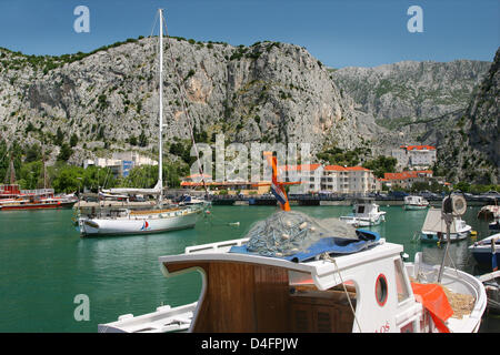 The photo shows the Croatian seaport Omis, situated 30 kilometres to the south of Split, which is one of the most charming towns of the Adriatic Sea in Dalmatia, Croatia, 08 June 2008. The city with its historic Old Town and fortress lies at the end of the canyon of Cetina and the river of the same name and in front of the steep chalk cliffs of the Omisko mountains. The varied land Stock Photo