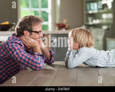Father and son admiring each other at table Stock Photo