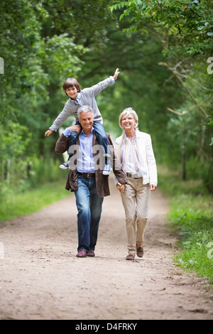 Couple walking with grandson on rural road Stock Photo