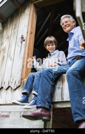Man and grandson sitting in doorway Stock Photo