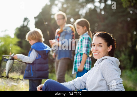 Family fishing together in tall grass Stock Photo