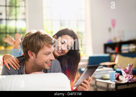 Couple using digital tablet on sofa Stock Photo